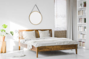 A Wooden Rustic Bed Frame And A Home Library Bookcase In A Natur