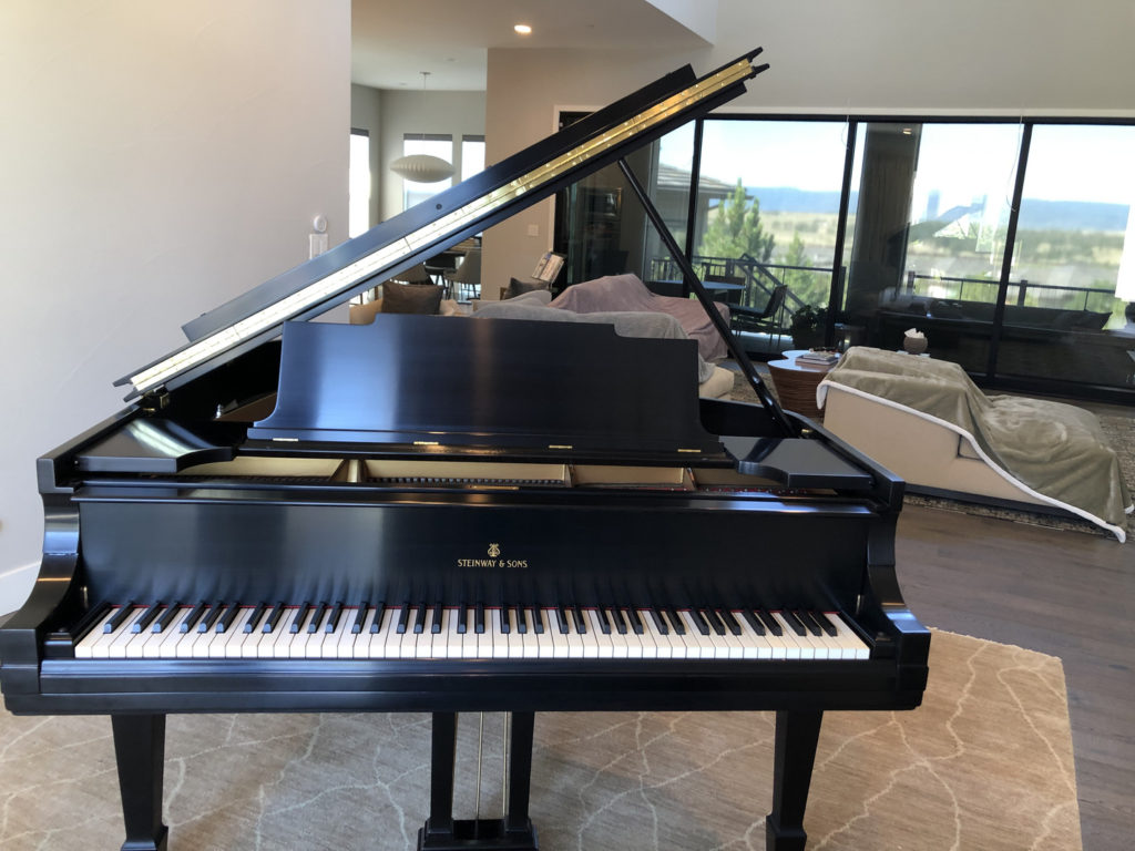 A piano sitting near a beautiful home's sitting room.